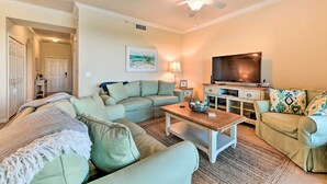 A living room with a ceiling fan, a television, and a sofa set. - Screened Patio & Resort Perks: Bradenton Condo! (Bradenton)