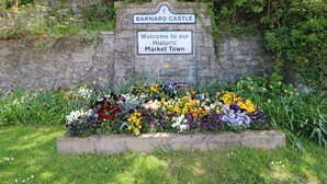 A welcome sign for Barnard Castle with a flower bed in front. - Low Shipley Mill (Barnard Castle)
