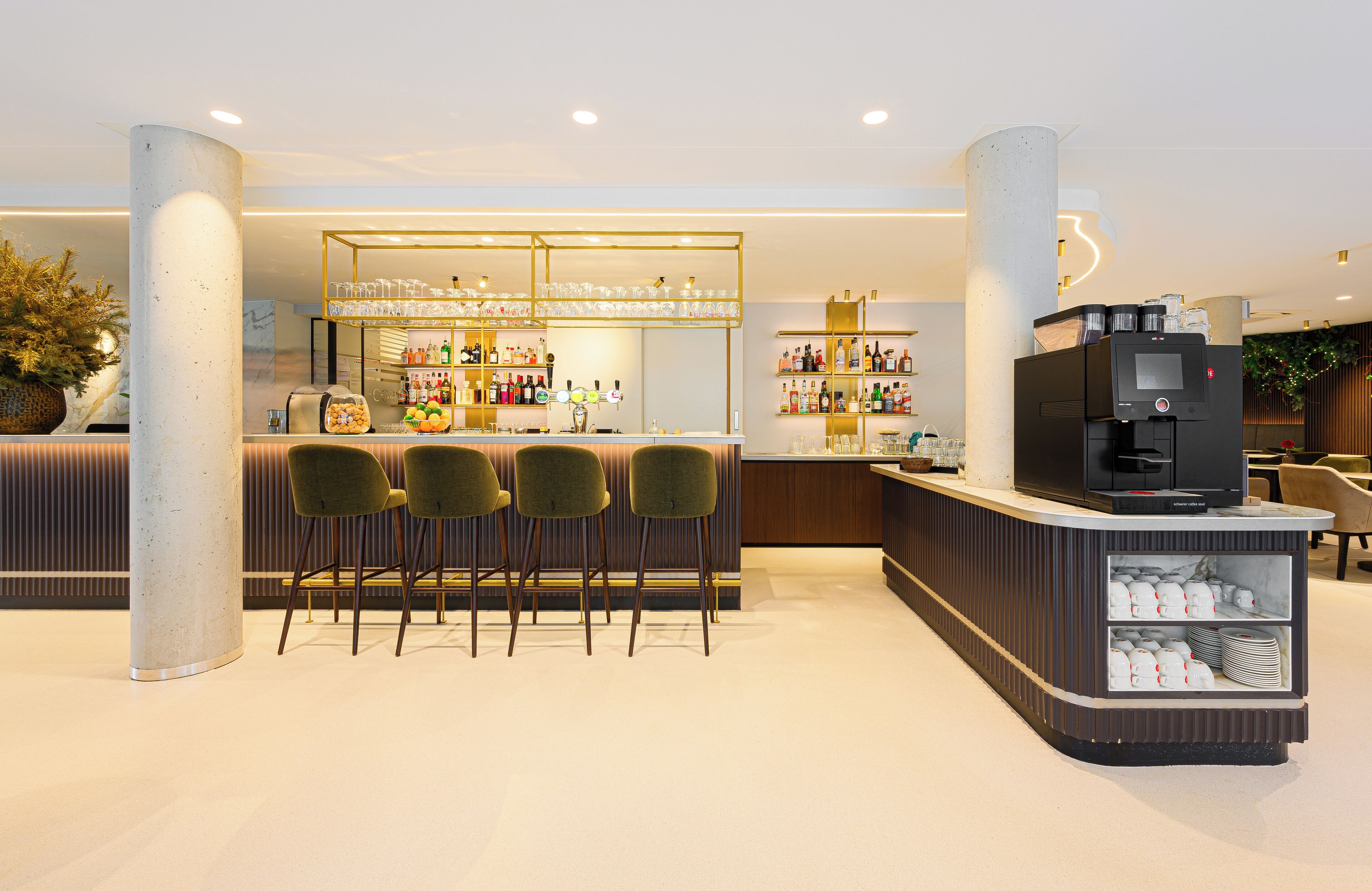 A modern bar area with a counter, bar stools, and a coffee machine.