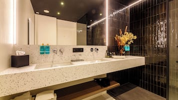 Un baño moderno con un espejo grande, dos lavamanos y una zona de tocador.