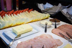 A buffet with sliced ham, cheese, and various fruits. - SOPHITA BUSINESS HOTEL (Itaberá)