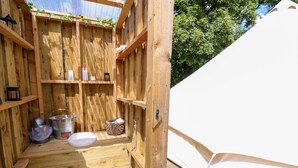 A wooden outdoor shower area with a white sink, shelves with toiletries, and a rope ladder. - Abercefel Retreat (Llandysul)