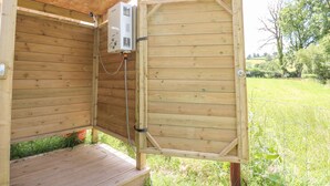 A wooden outdoor sauna structure with a metal door, a control panel, and a hose connected to the door. - Abercefel Retreat (Llandysul)