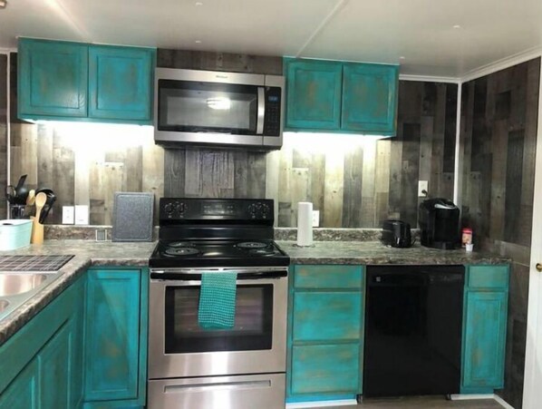 Fully equipped kitchen with a range, microwave, and dishwasher.