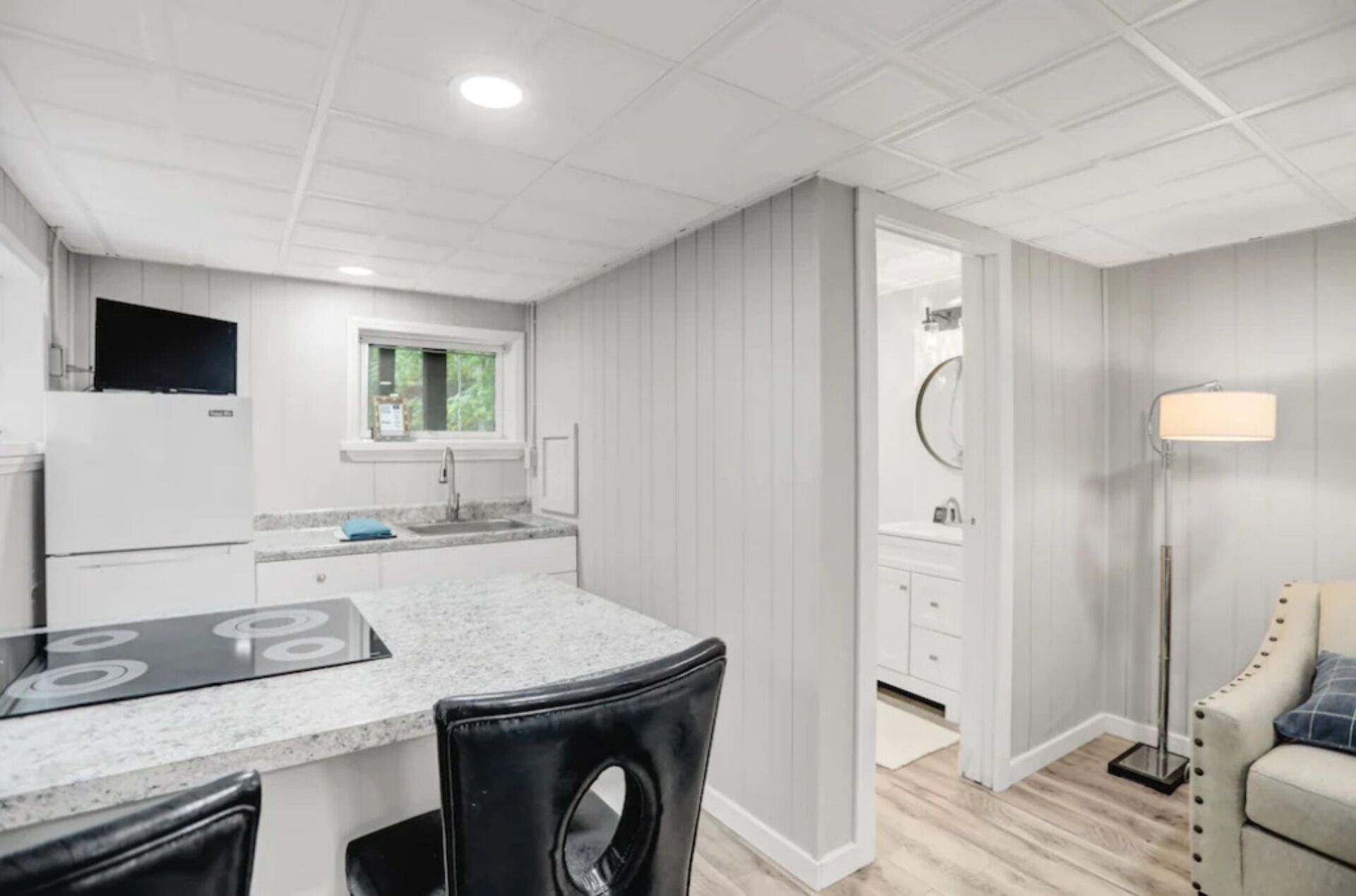 A modern kitchen with a built-in stove, a window, and a sink.
