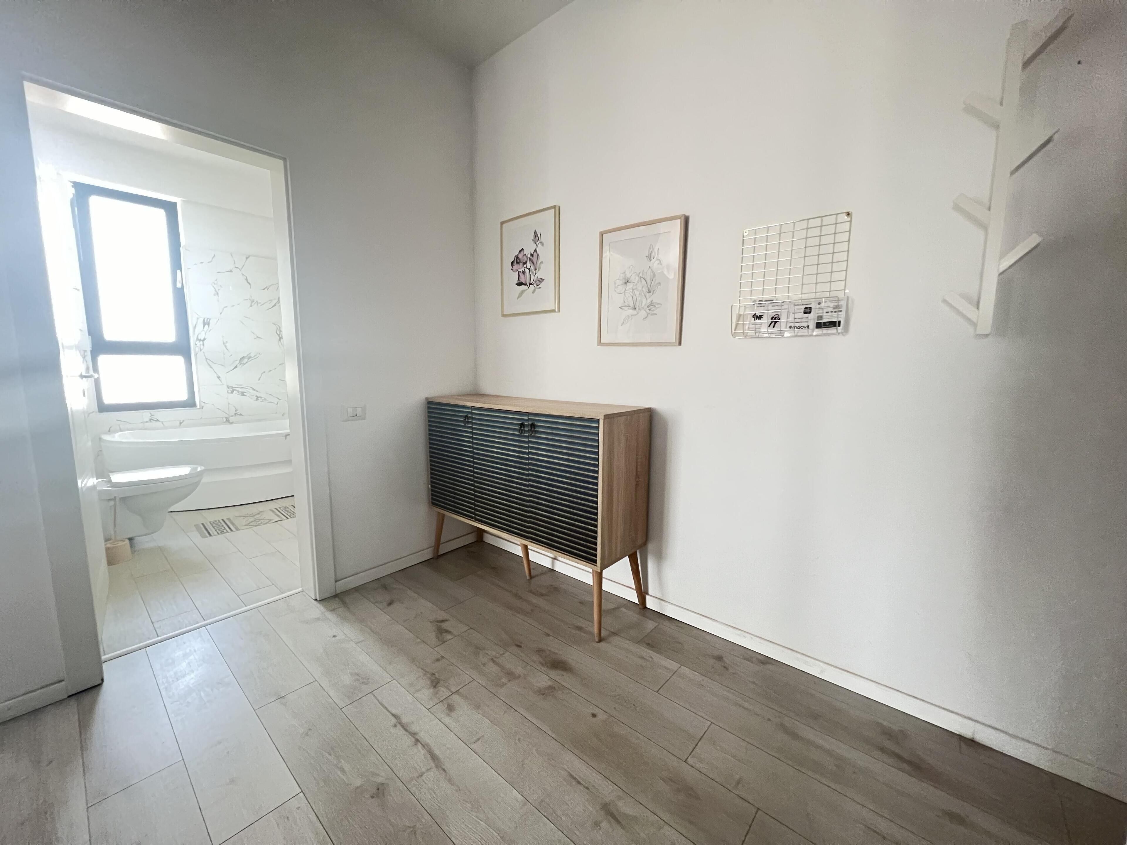 Un baño moderno y minimalista con lavamanos, inodoro y tocador de madera.