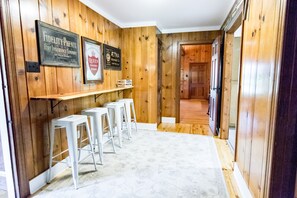 Un pasillo con paredes de madera, alfombra blanca y letreros enmarcados.