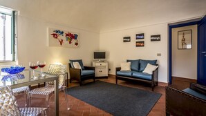 Un espace de vie compact comprenant un lit, un canapé, un téléviseur et un coin repas avec des chaises et une table.