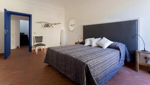 Une chambre à coucher avec un lit, une chaise, un bureau et une armoire.
