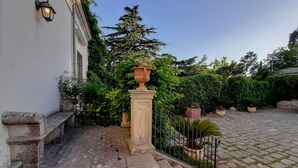 A stone staircase leading to a white building with a lantern on the wall. - Villa de Leva - Casa Verde (Modica)