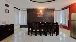 A modern dining area with a round ceiling light, a dining table with chairs, a microwave on a cabinet, and a refrigerator. - Casa a 5 Minutos del Hospital de La Mujer con Todos Los Servicios (Tehuacán)