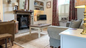 A cozy living room with a fireplace, a television, and comfortable seating.