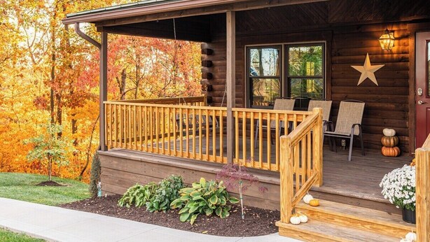 A log cabin with a porch, outdoor seating, and a star decoration.
