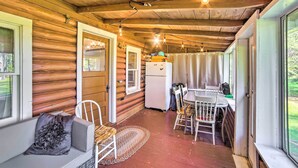 L’intérieur chaleureux d’un chalet comprend un coin repas, un espace salon avec un banc rembourré et un réfrigérateur.
