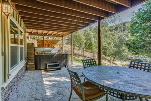 Une terrasse extérieure avec un sol en pierre, une table ronde et des chaises.
