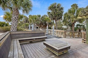 A wooden deck with built-in benches and a wooden fence.