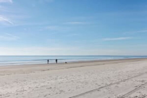 A beach with a clear sky and calm sea.