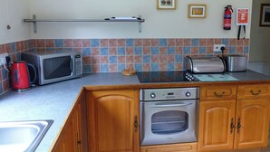 A compact kitchen with a microwave, toaster, and oven.