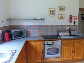 A compact kitchen with a microwave, toaster, and oven. - Bo Nan Taigh Cottage (Aberfoyle)