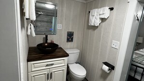 Ein kleines Badezimmer mit Toilette, Waschbecken und Spiegel.