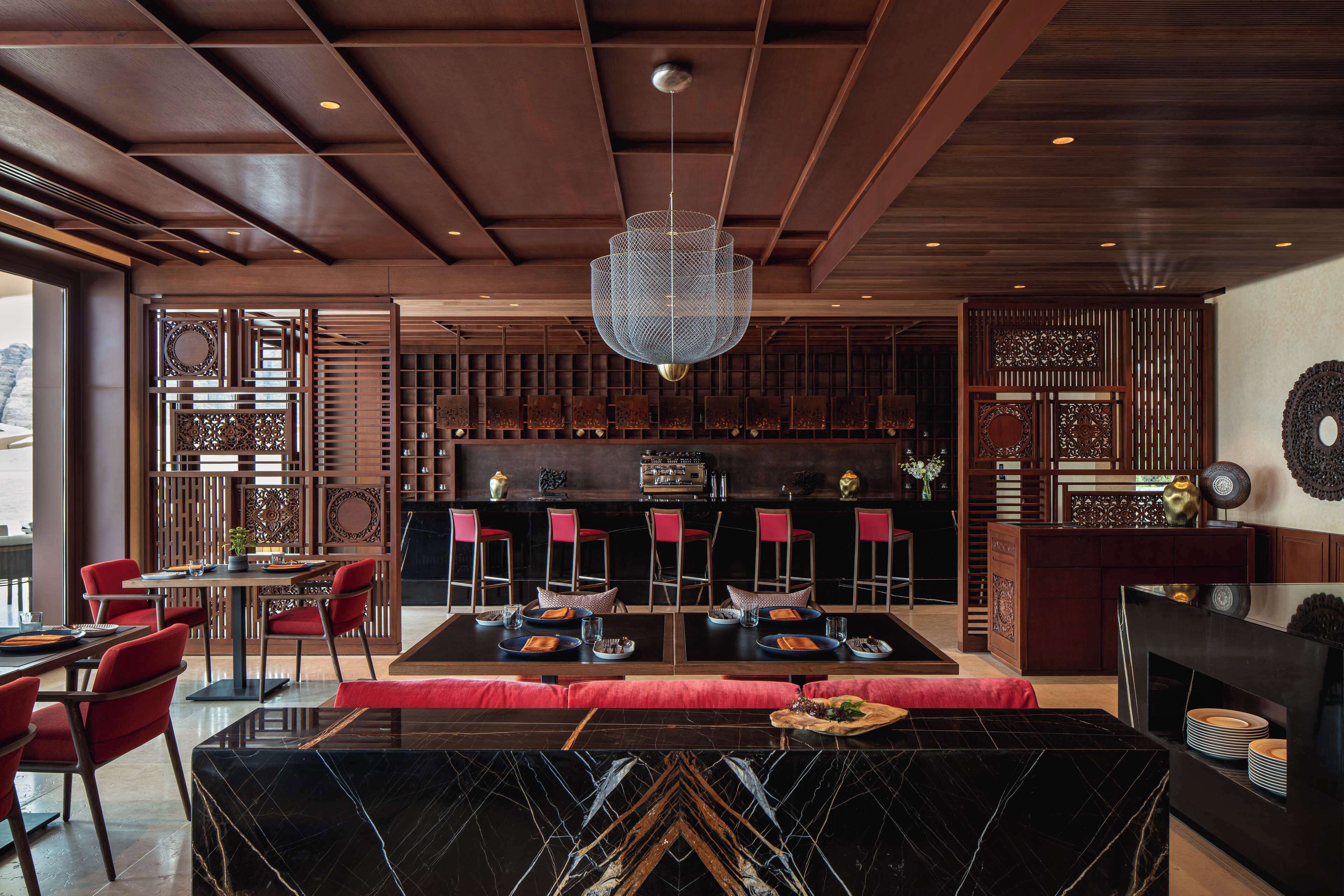 A modern interior with a bar area, seating, and a decorative ceiling.