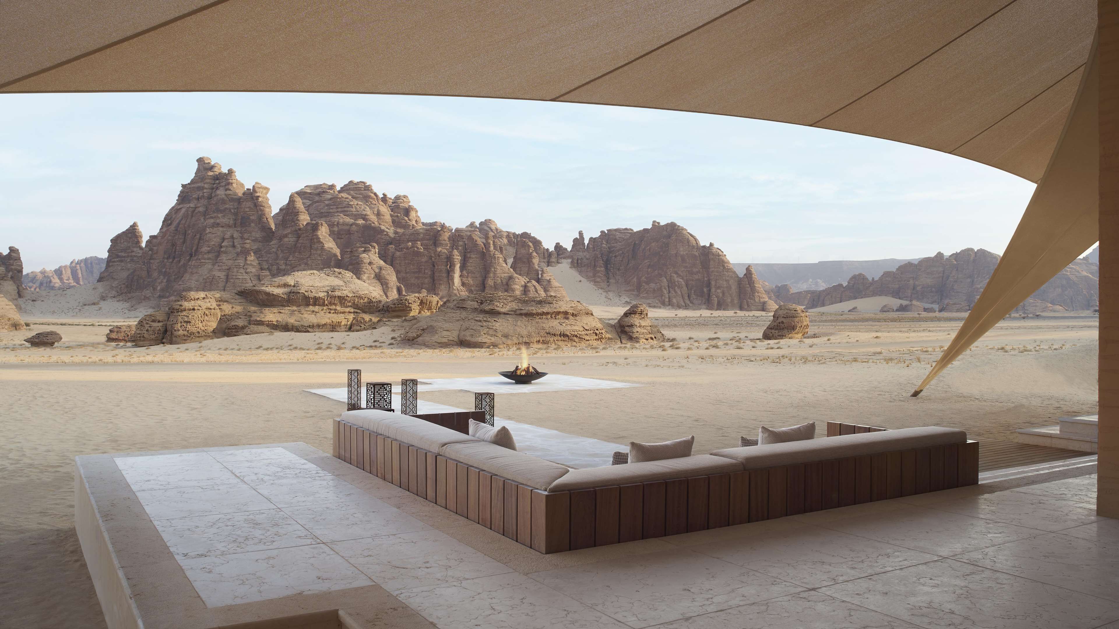 A desert landscape with a modern outdoor seating area featuring a fire pit.