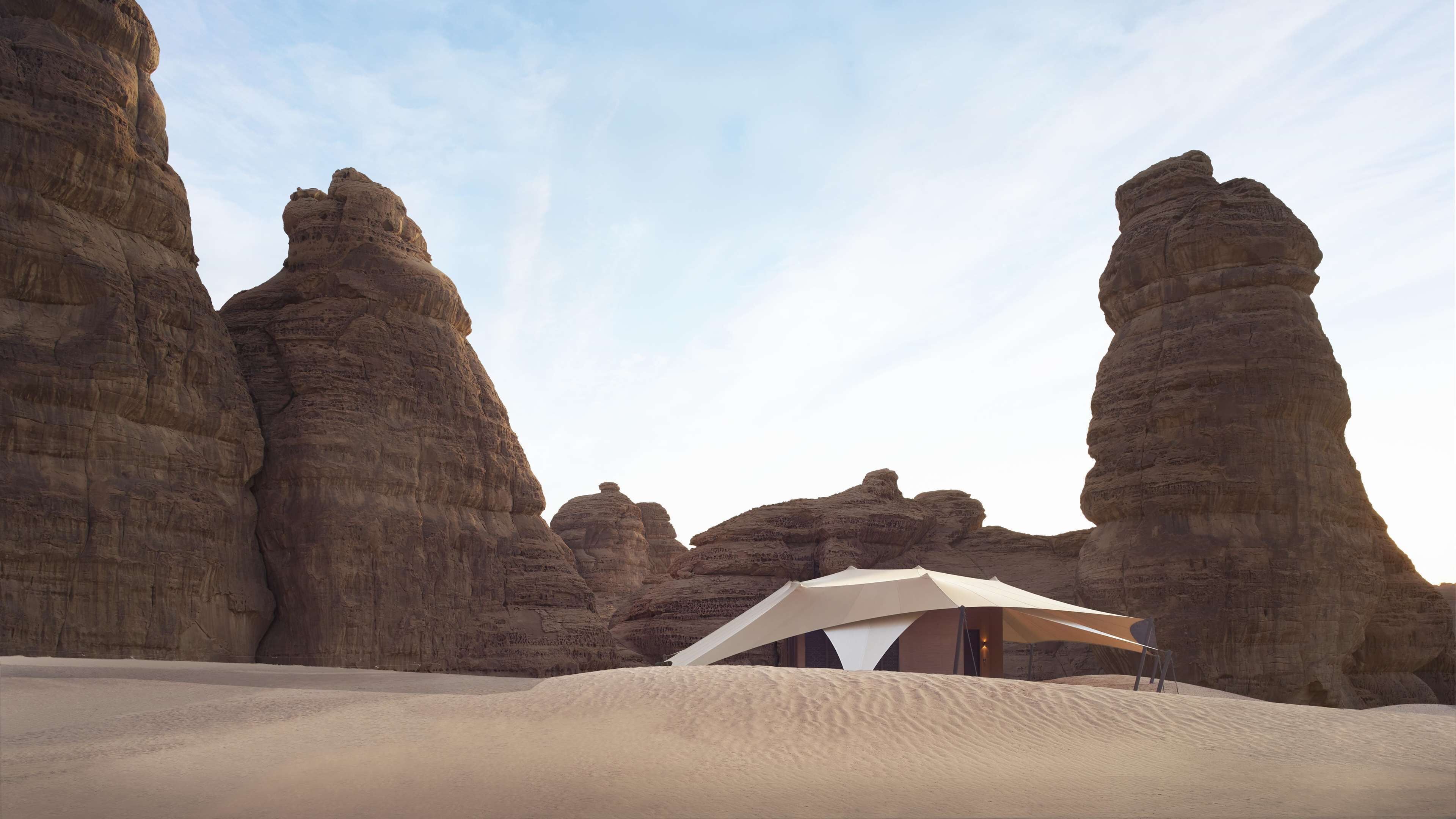 A desert tent set against a backdrop of large rock formations.
