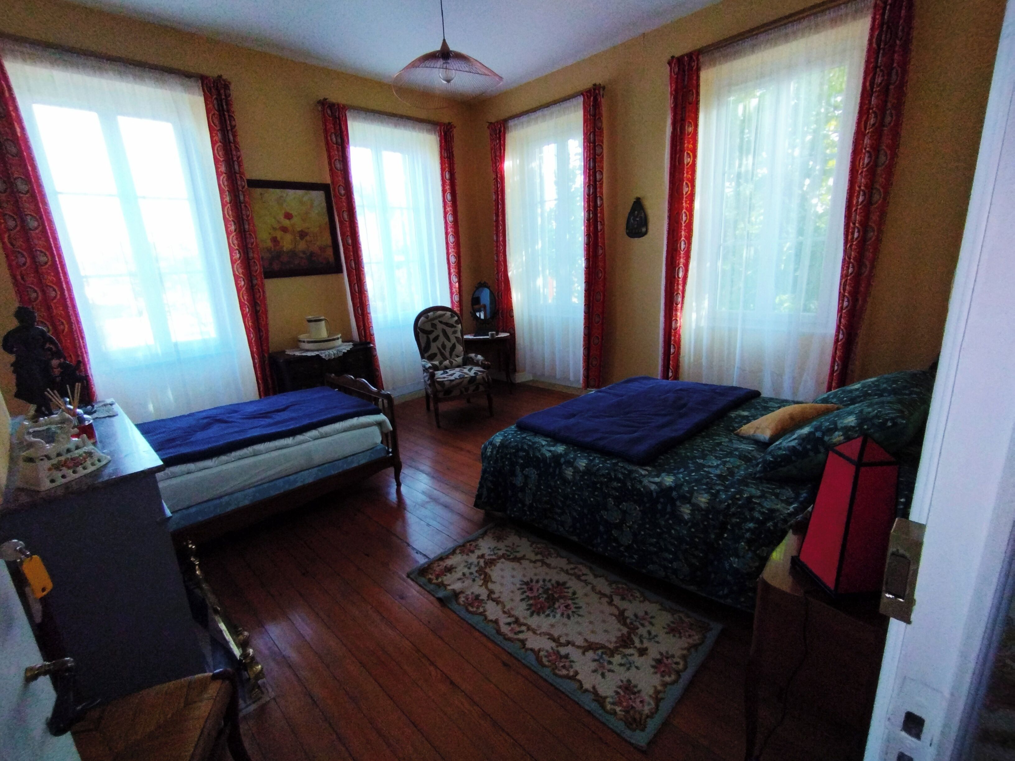 Une chambre avec deux lits, un bureau, une chaise et un tapis.