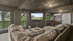 Een gezellige zithoek met een groot raam, een flatscreen televisie en een comfortabele zithoek.