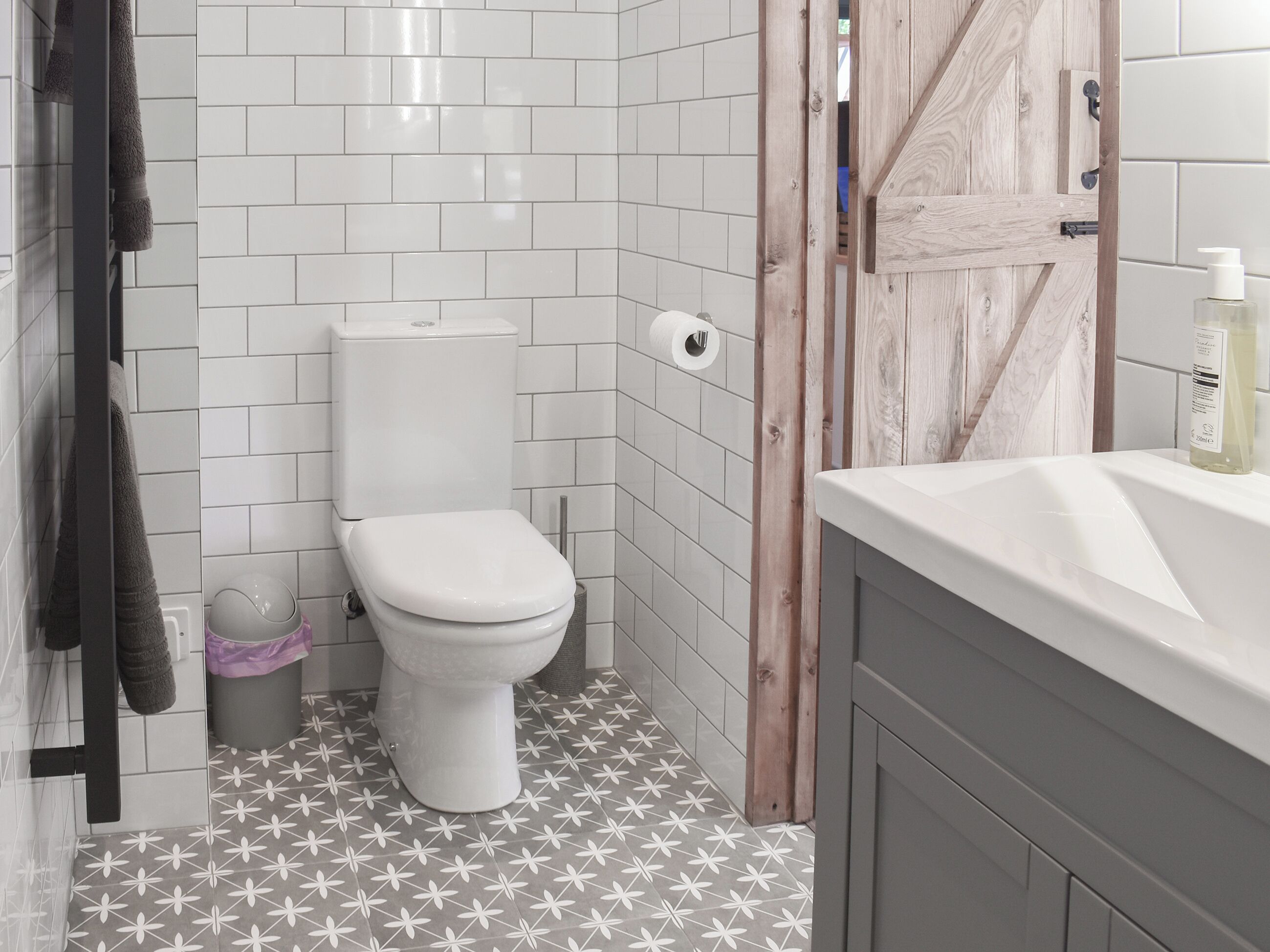 A bathroom with a toilet, a sink, and a shower area.