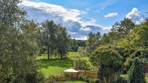 Un jardin luxuriant, agrémenté d’une clôture en bois, d’un sentier en pierre et d’une pelouse.