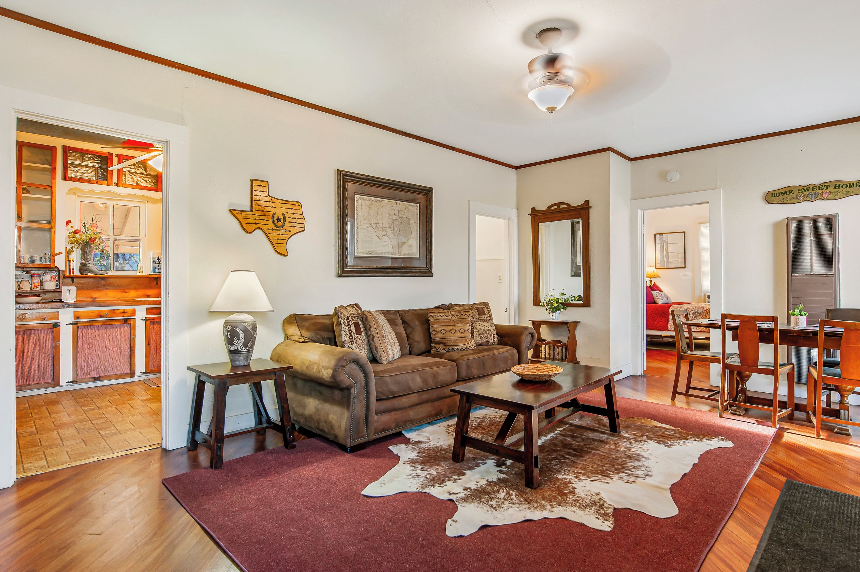 A living room with a sofa, coffee table, and a cowhide rug.