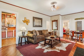 A living room with a sofa, coffee table, and a cowhide rug.