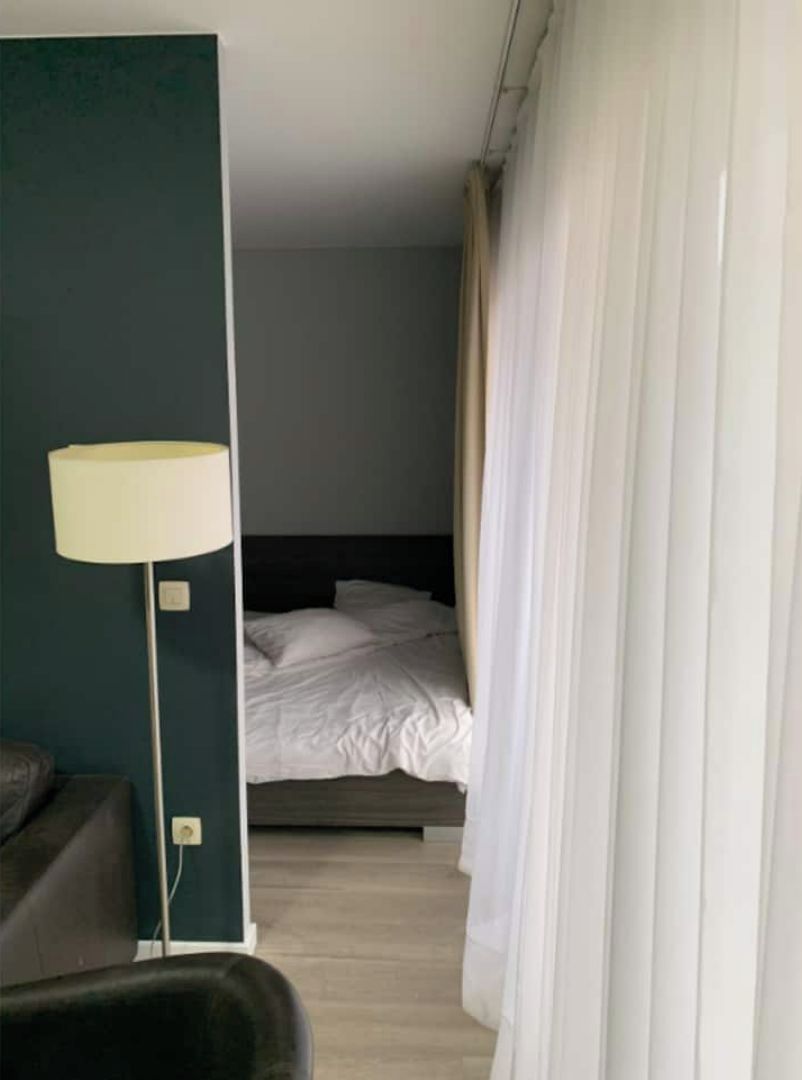 Una camera d'albergo con un letto, una scrivania e una lampada.
