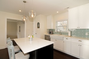 Enjoy cooking in this well-equipped kitchen with a central island, dishwasher, and coffee maker.