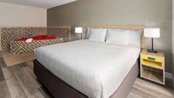 Ein Hotelzimmer mit einem großen Bett, zwei Nachttischen und einer Wand mit Muster.