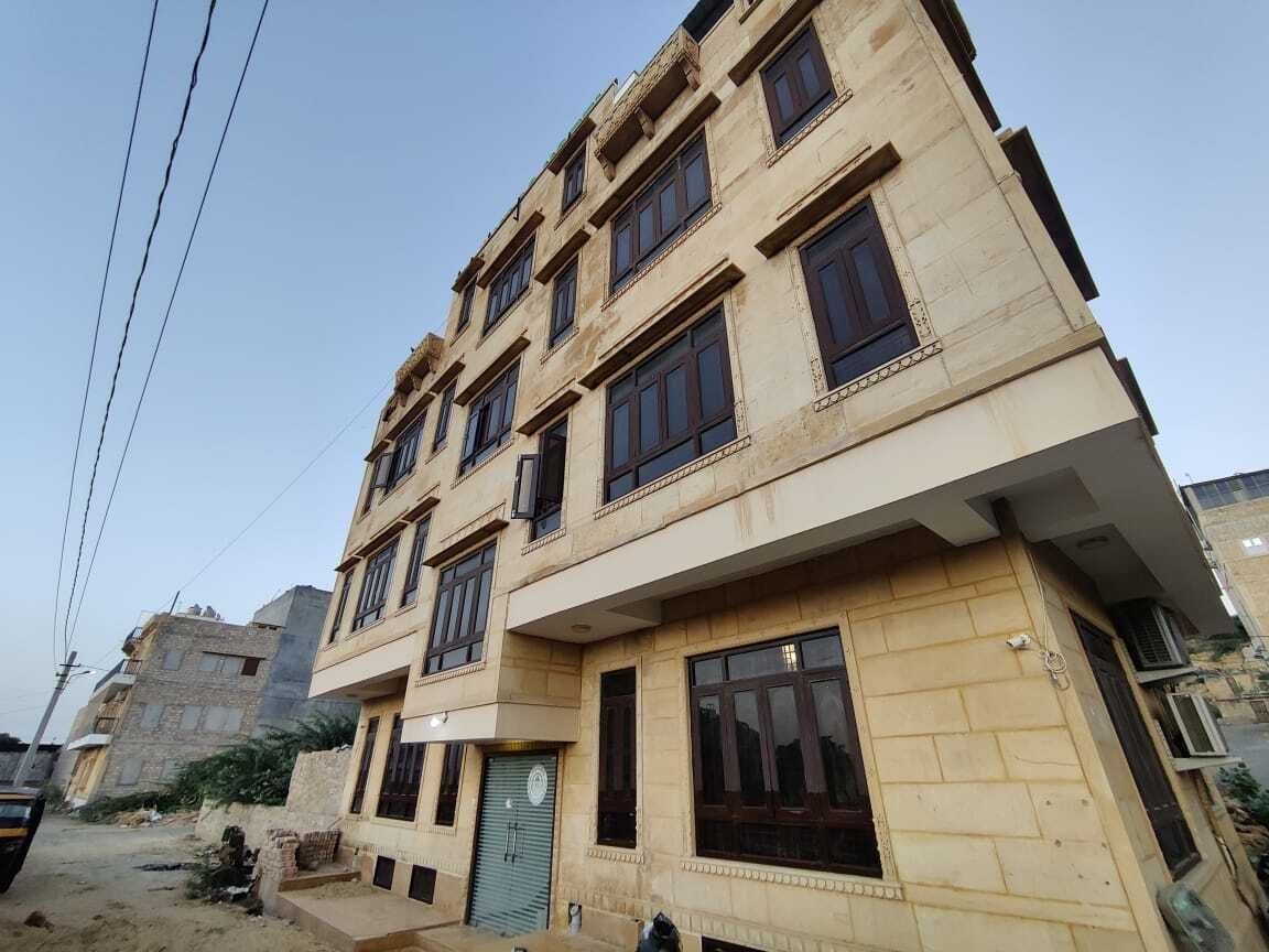 A multi-story building with a beige facade, multiple windows, and a visible entrance.