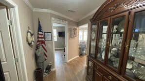 A hallway with a wooden cabinet displaying glassware, a tiled floor, and a door labeled "MERMAID ROOM". - Fish Camp - Backyard Caney Creek Fishing -  7.5 Miles from the Gulf (Bay City)