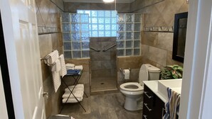 A bathroom with a shower, toilet, and sink. There is a window above the shower, and a ceiling fan. - Fish Camp - Backyard Caney Creek Fishing -  7.5 Miles from the Gulf (Bay City)