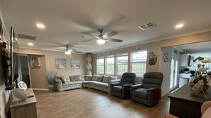 A spacious living room with a sectional sofa, two recliners, a coffee table, and a ceiling fan. - Fish Camp - Backyard Caney Creek Fishing -  7.5 Miles from the Gulf (Bay City)