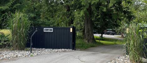 A gated driveway leading to a building with a sign reading "26651".