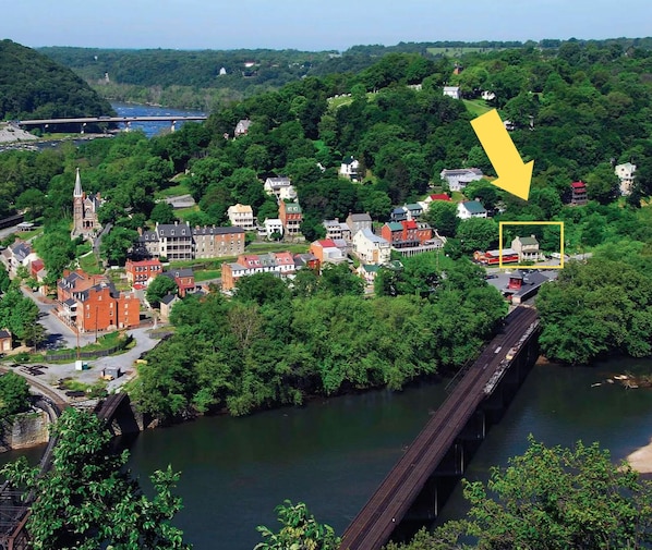 Une ville riveraine qui abrite un pont historique, une église et une flèche jaune indiquant un bâtiment particulier.