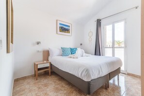 Ein Schlafzimmer mit einem Bett, einem Nachttisch und einem Fenster mit Vorhängen.