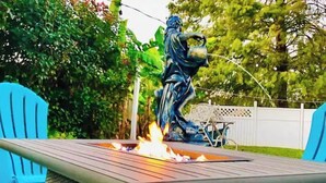 Un espace patio agrémenté d’un foyer et d’une statue.