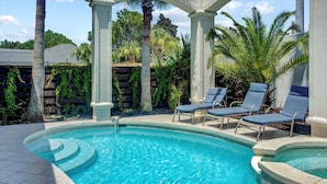 A swimming pool with lounge chairs and a pergola structure. - Private heated pool, Luxury Mediterranean Mansion sleeps 16 (Destin)