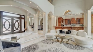 A spacious living room with a white sofa, a coffee table, and patterned rugs. - Private heated pool, Luxury Mediterranean Mansion sleeps 16 (Destin)