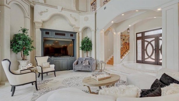 A spacious living room with a fireplace, a grey sofa, and a white couch. - Private heated pool, Luxury Mediterranean Mansion sleeps 16 (Destin)