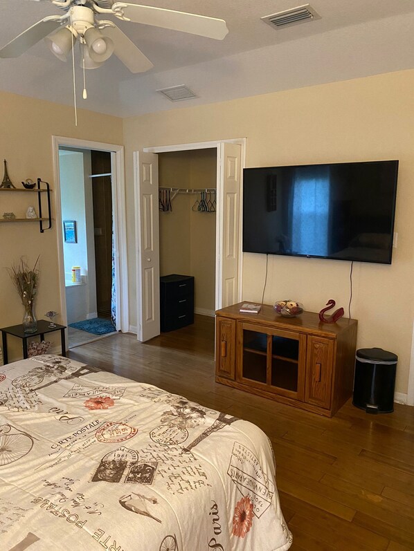 A bedroom with a bed, a TV, a wooden cabinet, and a closet. - Serene 3BR Retreat with 2 Baths - Your Perfect Getaway Awaits! (Port Charlotte)