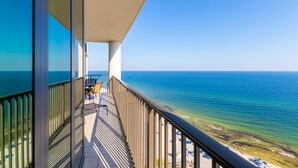 Ein Balkon mit Blick auf das Meer und den Strand.