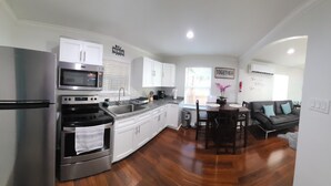 A modern kitchen with stainless steel appliances, white cabinets, and a dining area with a table and chairs.